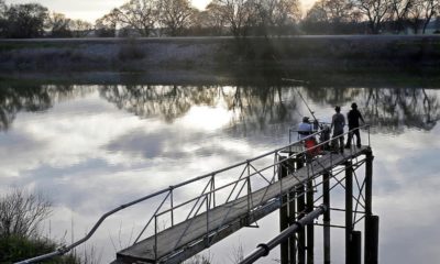 Photo of people trying to catch fish along the Sacramento River in the San Joaquin-Sacramento River Delta, near Courtland, Calif.