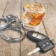 Photo of alcohol, keys and handcuffs symbolizing a drunk driving arrest