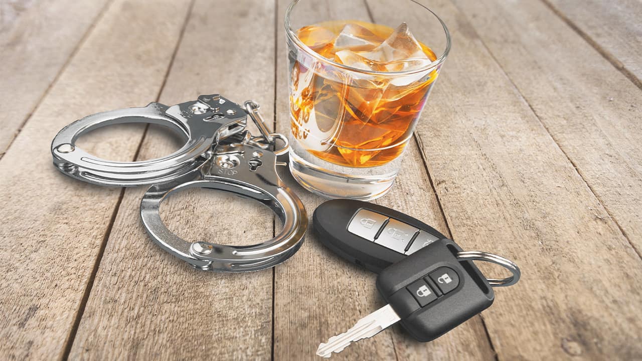 Photo of alcohol, keys and handcuffs symbolizing a drunk driving arrest