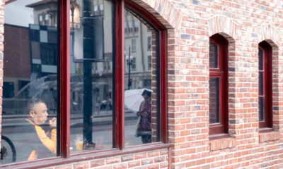 Photo of a man looking out the window of a restaurant