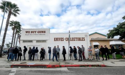 Photo of people lining up outside of a gun store