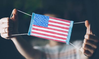 Photo of a man showing off a medical mask with an American flag on it