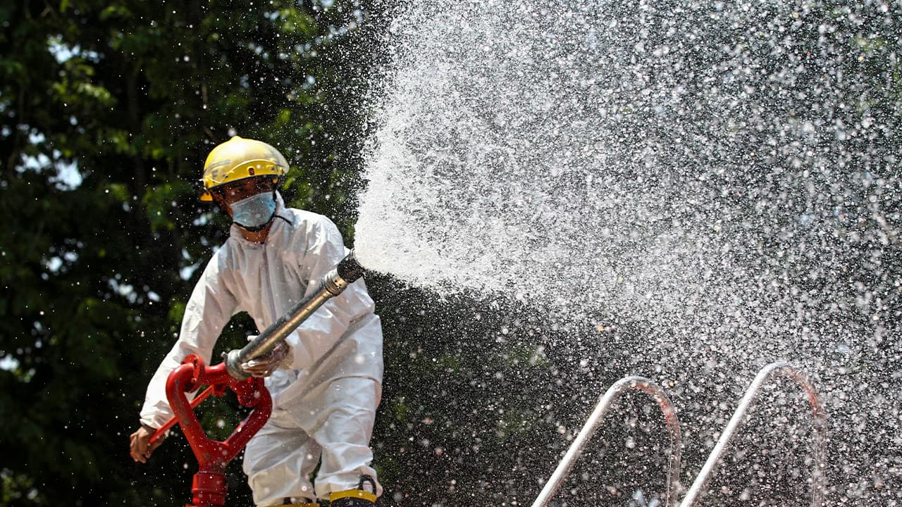 Photo of a firefighter spraying disinfectant