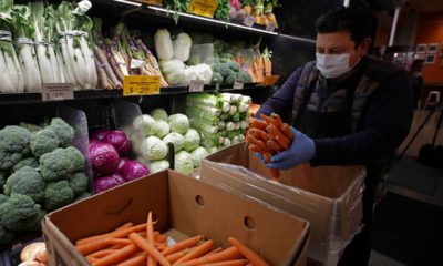 Photo of a worker stocking produce