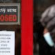 Photo of a man walking past a closed store