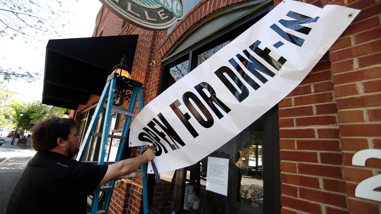 Photo of Jason Godbey hanging a dine-in sign