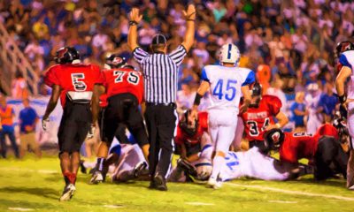 Photo of a referee signaling a touchdown in a high school football game