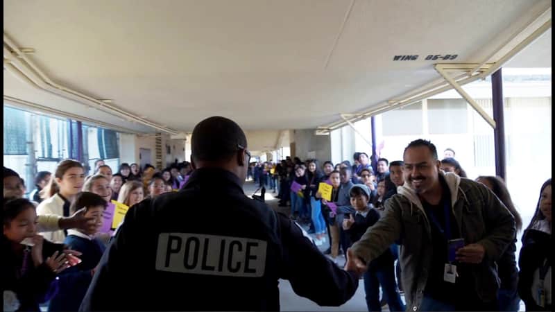 Photo of campus resource officer Martin saying goodbye to students at Cooper Academy in Fresno, Californiaooo
