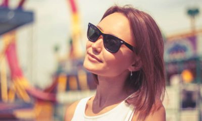 Photo of a young woman basking in the sunlight at an amusement park