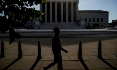 Photo fo a man walking past the Supreme Court