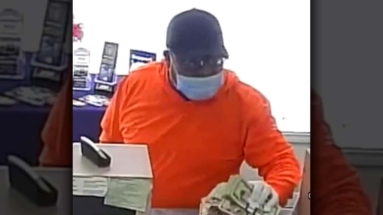 Image of man wearing orange shirt and blue surgical mask robbing a bank in Easton, CaliforniaMan weari
