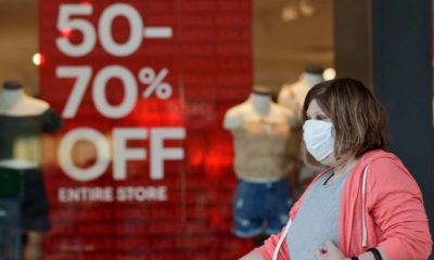Photo of a woman walking past a store