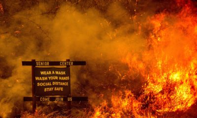 Photo of a sign for a senior center surrounded by wildfire flames