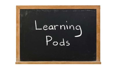 The words "Learning Pods" written in white chalk on a blackboard