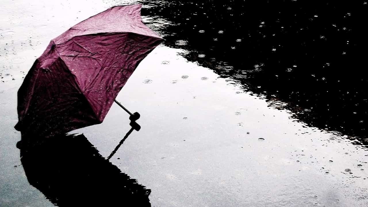 Photo of an umbrella on the ground during a rain shower